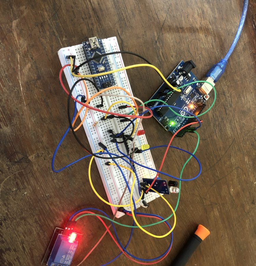 Montage complet : Arduino Uno et Nano sur plaque d'essai, LED rouge et jaune, capteur, module relais allumé