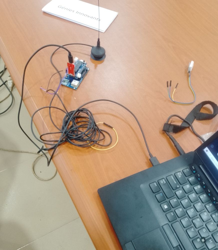 Nœud capteur sur table : carte microcontrôleur avec module radio et puce GPS, antenne externe à base magnétique, capteur relié par câble